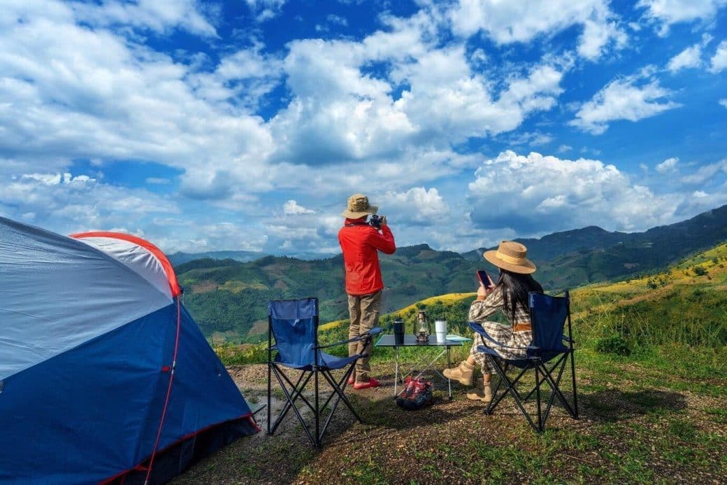 Couples camping while enjoying the mountain view.