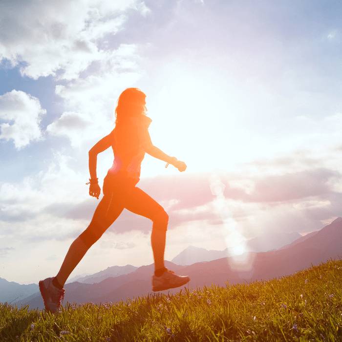 Silhouette of a runner on a mountain meadow.
